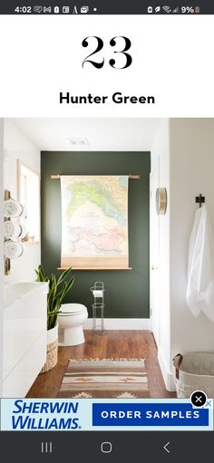 a bathroom with green walls and white fixtures, including a map hanging on the wall