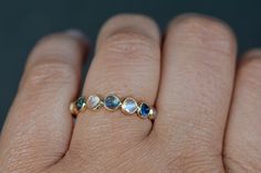 Lovely blue sapphire and moonstones are set in 18k gold. A delightful pattern this makes a great stacking ring. Moonstones and sapphires are alternated in a clean simple style which makes this really special. Stunning and gorgeous, this will make a delightful wedding band for a bride who has a September birthday or is simply captivated by the mesmerizing blue of a sapphire. This ring has lovely detailing with beautiful patterning at the stone setting (see additional pictures) making it the perfe