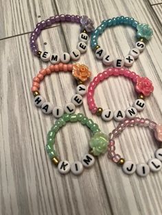 four personalized bracelets with flowers and name beads on the end of each bead