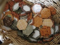 a wicker basket filled with assorted pieces of fabric