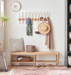 a coat rack with hats, scarves and shoes on it next to a bench