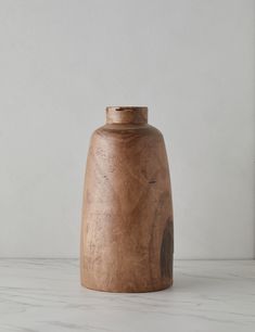 a wooden vase sitting on top of a white counter