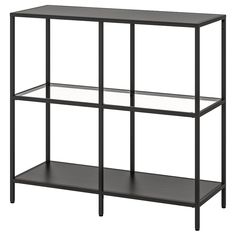 a black shelf with three glass shelves on each side, and one shelf below it