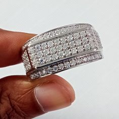 a hand holding a diamond ring in it's left hand