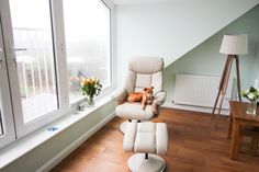 a dog sitting in a recliner chair next to a window with flowers on it