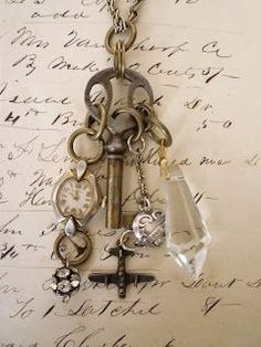 an old key and watch hanging from a chain on top of a piece of paper