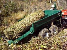 a man driving a green truck with a large tree on it's back