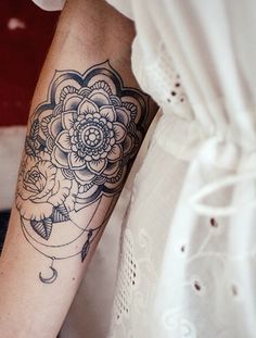 a woman's arm with a flower and moon tattoo on the left side of her arm