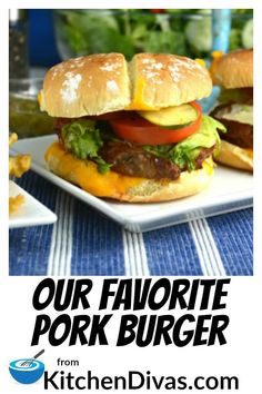 two hamburgers with lettuce, tomato and cheese are on a white plate