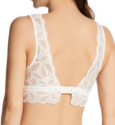 Sensual wireless bralette is sheer floral lace with flattering V-neckline. Perfect for lazy days at home or layering under a top. Bralette is styled with sheer floral lace. Seamed wireless cups have mesh lining at sides. Angled seams maintain cup shape. V-neckline has elastic edge to keep fit close. Goldtone metal charm is sewn at base of neckline. Elastic band is sewn underneath cups for great support. Scalloped underband secures at back with coated metal hook-and-eye closure. See Fitter's Comm Cream Lace Bra With Lace Trim, Elegant V-neck Bra For Spring, Elegant Underwire Bra With Lace Bodice, Elegant Bra With Lace Bodice, Feminine Lace With Built-in Bra, Feminine Cream Lace Bra, Lace Bodice Bra For Weddings, Delicate Lace Low-cut Feminine Bra, Feminine Delicate Lace Low-cut Bra