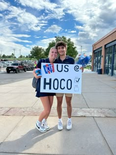 two people holding up a sign that says u s h oo co on it