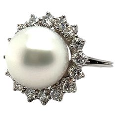 Elevate your elegance with our stunning pearl ring. Designed in 18 Karat white gold, it features a radiant South Sea cultural pearl at its heart, exuding natural charm. Encircled by a halo of 16 brilliant-cut diamonds totaling 0.96 carats, shimmering with G-H colour and vs clarity, this ring sparkles with every movement. It is commonly known, that pearls are renowned for their calming energy, believed to promote balance and harmony. Embrace the sophistication of pearls and diamonds in this perfect union of luxury and serenity. 16 diamonds, G-H/vs, brilliant cut, tot. 0.96 ct. 1 South Sea cultural pearl Weight: 9.85 gr. Size: 50 EU / 5.25 US Luxury White Pearl Ring With Halo, European Modern, Balance And Harmony, Sparkling Rings, South Seas, Pearl Diamond, Pearl Ring, Brilliant Cut Diamond, Cocktail Rings