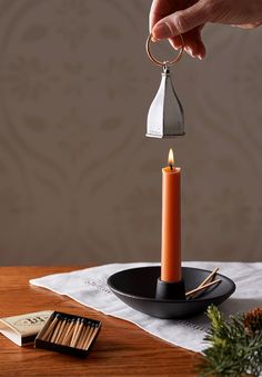 a candle is being held by a person with a ring around it on top of a table