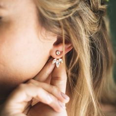 a close up of a woman's ear with two small flowers on the side