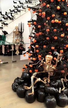 a halloween tree decorated with pumpkins and skeletons