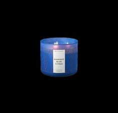 a blue candle that is lit up on a black background with the words midnight citrus