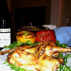 there is a large turkey on the plate next to a bottle of wine and other food