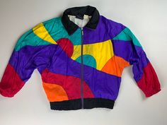 "Vintage 80's Multi Colored Windbreaker  Size Medium  Oversized Look Batwing Sleeve  Nylon  Made in Taiwan  Zipper closure  Elastic waistband and cuffs  Pockets  Vibrant colors  Great condition 26\" across the chest  19\" underarm to cuff 27\" from top of collar fold to hem" Retro Multicolor Windbreaker For Streetwear, 90s Style Multicolor Windbreaker For Spring, Retro Multicolor Windbreaker For Fall, Spring Multicolor Nylon Windbreaker, Vintage Multicolor Windbreaker For Spring, Retro Multicolor Windbreaker For Winter, Retro Multicolor Winter Windbreaker, Retro Multicolor Spring Windbreaker, Vintage Multicolor Windbreaker For Fall