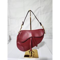 This Authentic Christian Dior Calfskin Saddle Bag Burgundy Red Is In Its Good Pre-Owned Condition. The Exterior Is Clean And Beautiful With Minor Hairline Scratches To It. The Interior Is Clean. There Are Some Scratches To The Gold Hardware. The Bag Is In Good Condition. Kindly Note That Picture On Mannequin Is Not Ours But For Size Reference And Fit. Dimensions Longest Length : 9.5” Width: 2.5” Height: 8.5” Drop: 7” Long Length, Burgundy Red, Gold Hardware, Saddle Bags, Mini Bag, Christian Dior, Calf Skin, Dior, Bag Lady