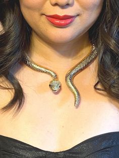 Goldtone SNAKE statement necklace, choker style. This necklace has been purchased for Halloween, weddings, concert tour accessory, cosplay, first date wear, FYP videos and more.  Check out the comments by buyers. What can you style it with?? What exceptional day will you wear it for??!?!?  ENJOY!! Wearable sizing: 5-1/2" diameter across Actual measured sizing: 6-1/2" across and 8" from top to end of snake's tail Not intended for children ages 13 and under. Party Snake Chain Metal Choker, Party Metal Snake Chain Choker, Adjustable Necklaces For Halloween Costume Party, Adjustable Metal Choker For Cosplay, Metal Halloween Party Jewelry, Metal Beaded Choker For Party, Gothic Gold Necklace With Clavicle Chain, Adjustable Chain Jewelry For Halloween Party, Gold Metal Necklace For Halloween