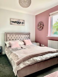 a bedroom with pink walls and a large bed