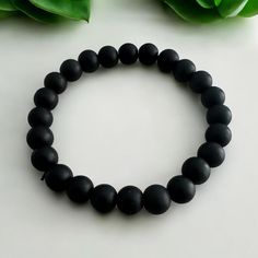 Matte Onyx Natural Stone Bracelet Natural and Stylish: The Matte Onyx Natural Stone Bracelet is the perfect choice for those seeking elegance and sophistication. The matte finish of the natural onyx stones gives the bracelet a modern yet refined appearance. Quality and Durability: Onyx stones are known for their longevity and resilience due to their natural properties. The matte surface highlights the stone's uniqueness and natural beauty, ensuring each bracelet is distinct and eye-catching. Energy and Balance: Onyx is traditionally believed to promote tranquility and balance. This bracelet is ideal for both daily wear and special occasions, offering both style and potential benefits. Comfortable Wear: Its elastic design ensures an easy fit and comfortable wear for any wrist size. The brac Elegant Matte Black Adjustable Jewelry, Elegant Adjustable Matte Black Jewelry, Elegant Black Hypoallergenic Bracelets, Hypoallergenic Black Round Bracelets, Elegant Black Hypoallergenic Beaded Bracelets, Black Hypoallergenic Beaded Bracelets, Hypoallergenic Black Beaded Bracelets, Bracelet Style, Natural Stone Bracelets