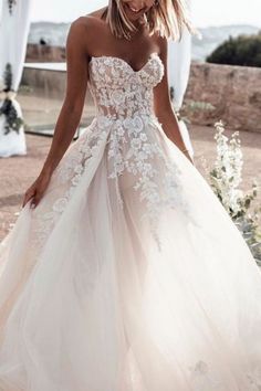 a woman in a wedding dress is walking down the aisle with her hand on her hip