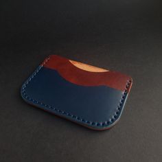 The colors of this simple leather card holder say it all. The classic combination of brown and navy blue is unbeatable. It is a matching-it-all case that will comfortably fit into every pocket or bag compartment. Made of vegetable tanned leather, this card holder with build a beautiful patina over time and will get softer and softer. The beauty of vegetable tanned leather lays in the way it changes and ages with time, collecting scarfs and marks of wear. The blue thread handstitched through roun Blue Leather Wallet With Coin Pocket, Blue Leather Card Holder For Daily Use, Blue Leather Trifold Wallet With Card Slots, Blue Leather Coin Purse With Card Slots, Blue Leather Coin Purse With Interior Card Slots, Blue Leather Card Holder With Interior Slots, Modern Brown Coin Purse With Card Slots, Blue Rectangular Leather Card Holder, Rectangular Blue Leather Card Holder