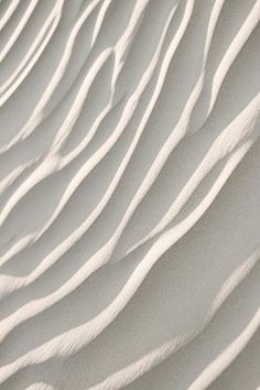 an abstract photo of sand dunes in the desert, with white lines on top and bottom