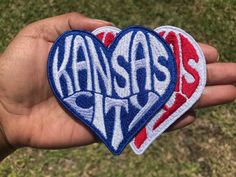 someone holding two kansas city heart patches in their hand