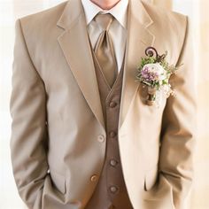 a man in a suit and tie standing next to a window with his hands in his pockets