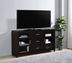 a flat screen tv sitting on top of a wooden entertainment center next to a potted plant