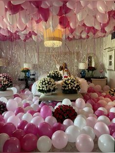 a room filled with lots of balloons and flowers