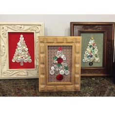 three framed pictures with buttons on them in different colors and sizes, each decorated as a christmas tree