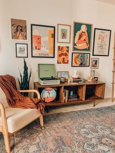 a living room filled with furniture and pictures on the wall next to a carpeted floor