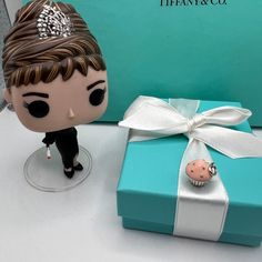 a small figurine next to a blue gift box