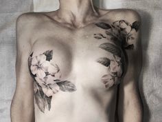 a shirtless man with flowers on his chest and chest tattooing it's right side