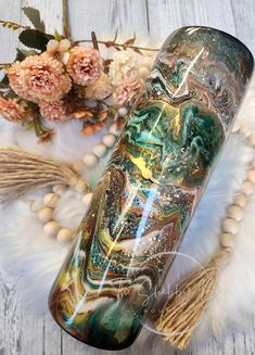 a glass vase sitting on top of a white fur rug next to flowers and beads