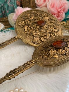 Vintage Globe 24K Plated Vanity Set  Hand Mirror& Brush. This set is in excellent condition. The hand mirror even has original "Globe 24K Gold Plated " gold foil sticker on it. The mirror measures 12 inches long. It has a beautiful piece of oval faceted amber glass on decorative side with filigree design and circle of raised flowers surrounding the glass. The mirror is beveled, bright and reflective and measures 6 inches across. There is a small amount of gold loss on the bottom of the handle on mirror side. The brush measures 9 inches long. It also has the filigree design with ring of raised flowers. It is marked "Globe Made in USA" in clear part of bristle holder. The comb measures 8.25 inches long and it is also marked "Globe USA" on both ends of the clear plastic comb part. It has an e Gold Objects, Antique Objects, Vanity Accessories, Super Nails, Vintage Makeup, Vintage Vanity, Filigree Design, Hand Mirror, Pinterest Closet