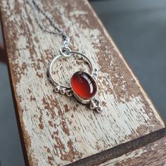 Beautiful red agate set in silver. It comes with a 60 cms stainless steel chain. Nickel-free Amber Sterling Silver Necklace, Silver Carnelian Round Pendant Jewelry, Amber Cabochon Necklaces In Sterling Silver, Amber Cabochon Necklace In Sterling Silver, Amber Sterling Silver Necklaces With Cabochon, Amber Sterling Silver Necklace With Cabochon, Silver Carnelian Cabochon Necklace, Red Nickel-free Pendant Necklace, Silver Carnelian Jewelry With Large Pendant