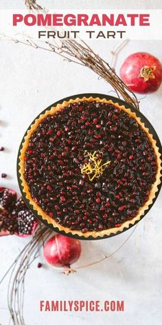 an overhead view of a fruit tart on a table with apples and dried berries