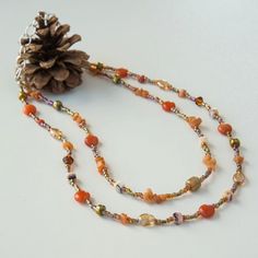 Beaded necklace in orange, gold, and brown tones by AubergineOriginals on Etsy Orange Multi-strand Polished Beaded Necklaces, Orange Multi-strand Beaded Necklace With Polished Beads, Orange Multi-strand Polished Beaded Necklace, Brown Czech Glass Beaded Necklaces With Gemstone Beads, Brown Czech Glass Gemstone Beaded Necklaces, Brown Czech Glass Beaded Necklace With Gemstone Beads, Brown Beaded Necklace With Czech Glass And Gemstone Beads, Orange Czech Glass Beaded Necklaces, Orange Carnelian Beaded Necklace With Colorful Beads