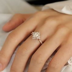 a close up of a person's hand with a diamond ring on their finger