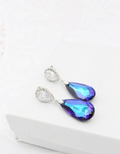 "If you are looking for purple earrings to make a statement, these Luxury Heliotrope color Swarovski Earrings are your best option! They are also a big favorite for Peacock themed Weddings and the teardrop crystals feature multiple colors, predominantly Purple and Turquoise. A must have for your Purple outfit! These luxury Teardrop Earrings are made of sparkly Purple Genuine Swarovski crystals that hang from nickel free Solid Sterling Silver post earrings (the whole earring, not just the post!) Elegant Peacock Earrings For Wedding, Elegant Peacock Colored Earrings For Wedding, Elegant Peacock-colored Earrings As A Gift, Elegant Peacock Colored Earrings For Gift, Elegant Peacock-colored Earrings For Gift, Peacock Colored Earrings For Wedding, Earrings To Make, Turquoise Earring, Peacock Jewelry