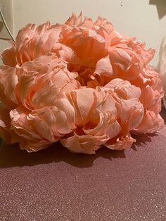 a large pink flower sitting on top of a table