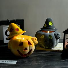 two pumpkins with faces carved into them sitting next to a lantern and a clock