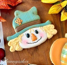 decorated cookies with frosting and icing on a wooden table next to fall leaves