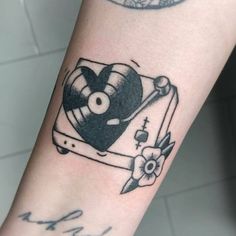 a tattoo on the arm of a person with a clock and heart shaped object in it