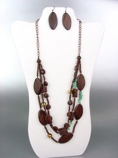 Artisanal NATURAL Brown Wood Beads & Genuine Turquoise Stone Beads & Faceted Bronze Metallic Crystals Long Layered Necklace Earrings Set     Gorgeous Style!  This fabulous Artisanal long & layered drape necklace set has 3 layered strands of assorted shape brown wood beads intermixed with genuine turquoise stone beads & faceted bronze metallic crystals all on antique copper metal chain. The matching fish hook earrings are the perfect complement to the set.       ***  BRAND NEW  ***   Assorted Sha Long Necklace Set, Layered Necklace Set, Fashion Jewelry Sets, Fish Hook Earrings, Turquoise Stones, Genuine Turquoise, Layered Necklace, Natural Brown, Brown Wood