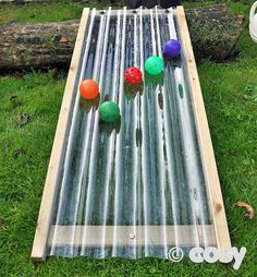 an outdoor musical instrument is laying on the grass with balls and sticks sticking out of it